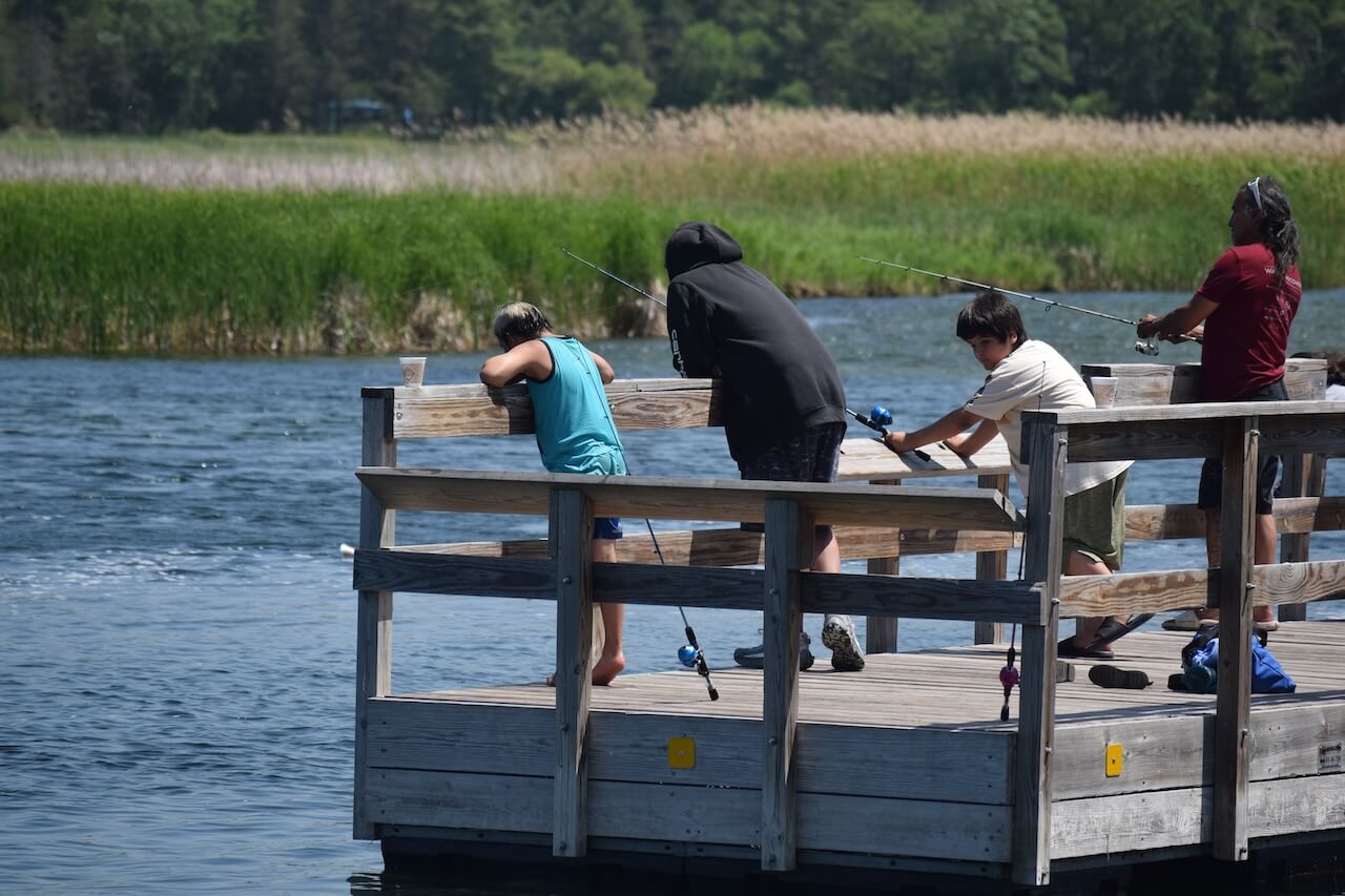 Group of people fishing from dock